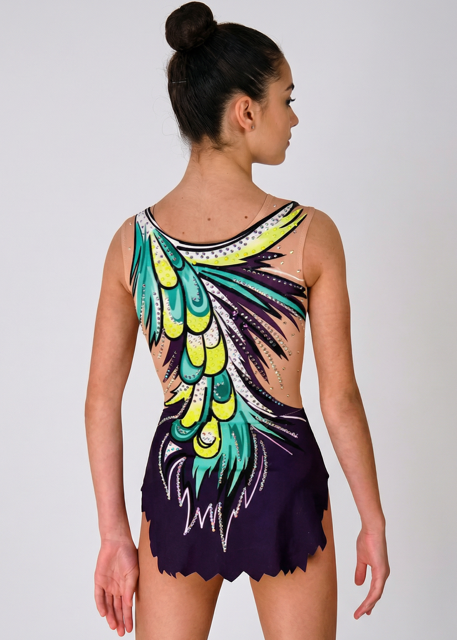 Maillot rítmico morado con transparencias, pedrería y gran diseño verde-amarillo de plumas creando un estilo dinámico y llamativo.
Maillot de gimnasia rítmica morado con transparencias, pedrería y motivo asimétrico de plumas verdes y amarillas en un estilo vibrante.
Espalda de maillot rítmico morado con transparencias, pedrería y gran diseño de plumas verdes y amarillas en un estilo enérgico.