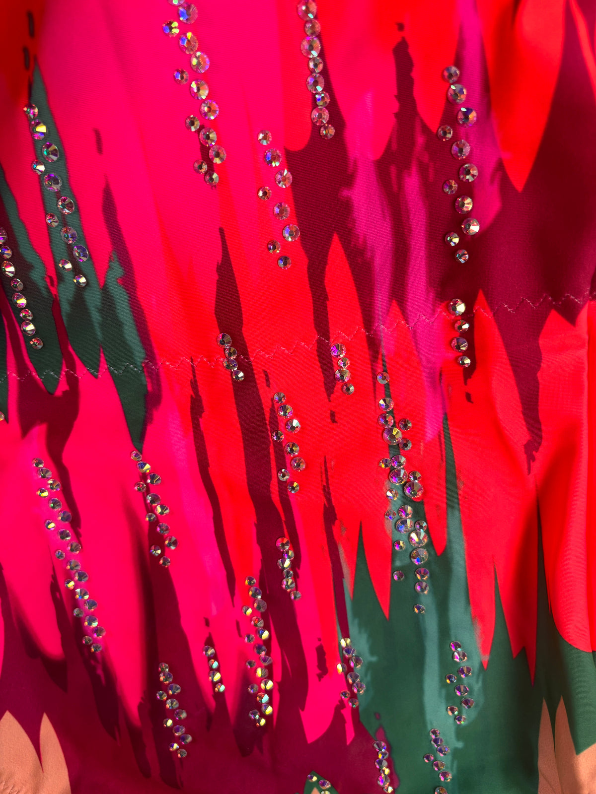 Dettaglio ravvicinato di Matisse con file di pietre brillanti su forme fucsia, rosse e verde scuro.