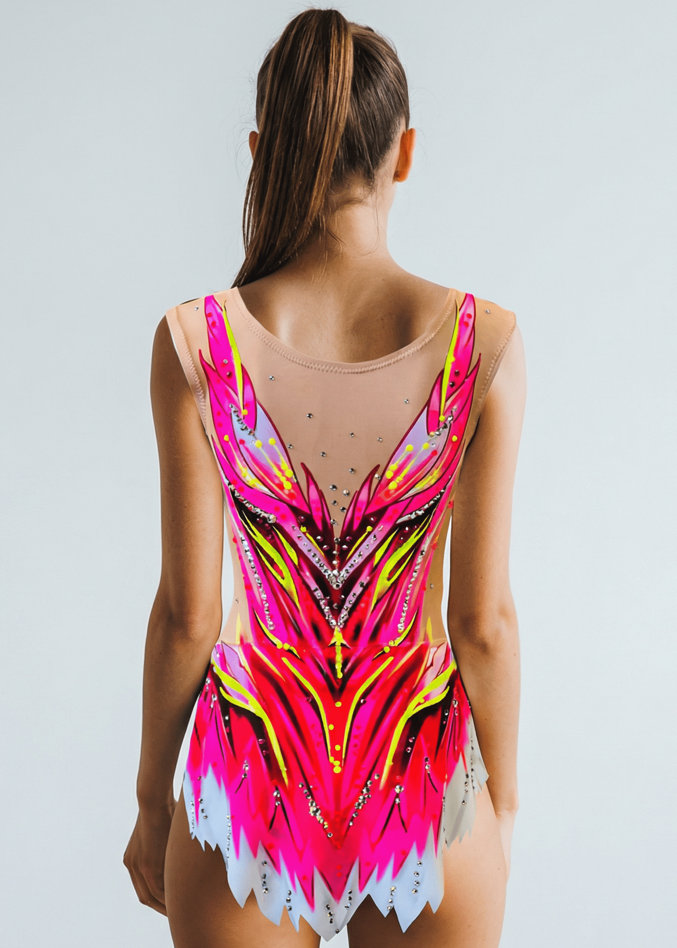 Maillot de gimnasia rítmica translúcido con tonos fucsia, amarillo y gris, pedrería brillante y diseño posterior simétrico de líneas afiladas.
Maillot rítmico translúcido en fucsia, rosa y amarillo, con pedrería fina y patrón posterior vibrante de formas estilizadas.
Maillot de gimnasia rítmica con base translúcida, degradados fucsia y gris, detalles de pedrería y estilo posterior dinámico en forma de llamas.