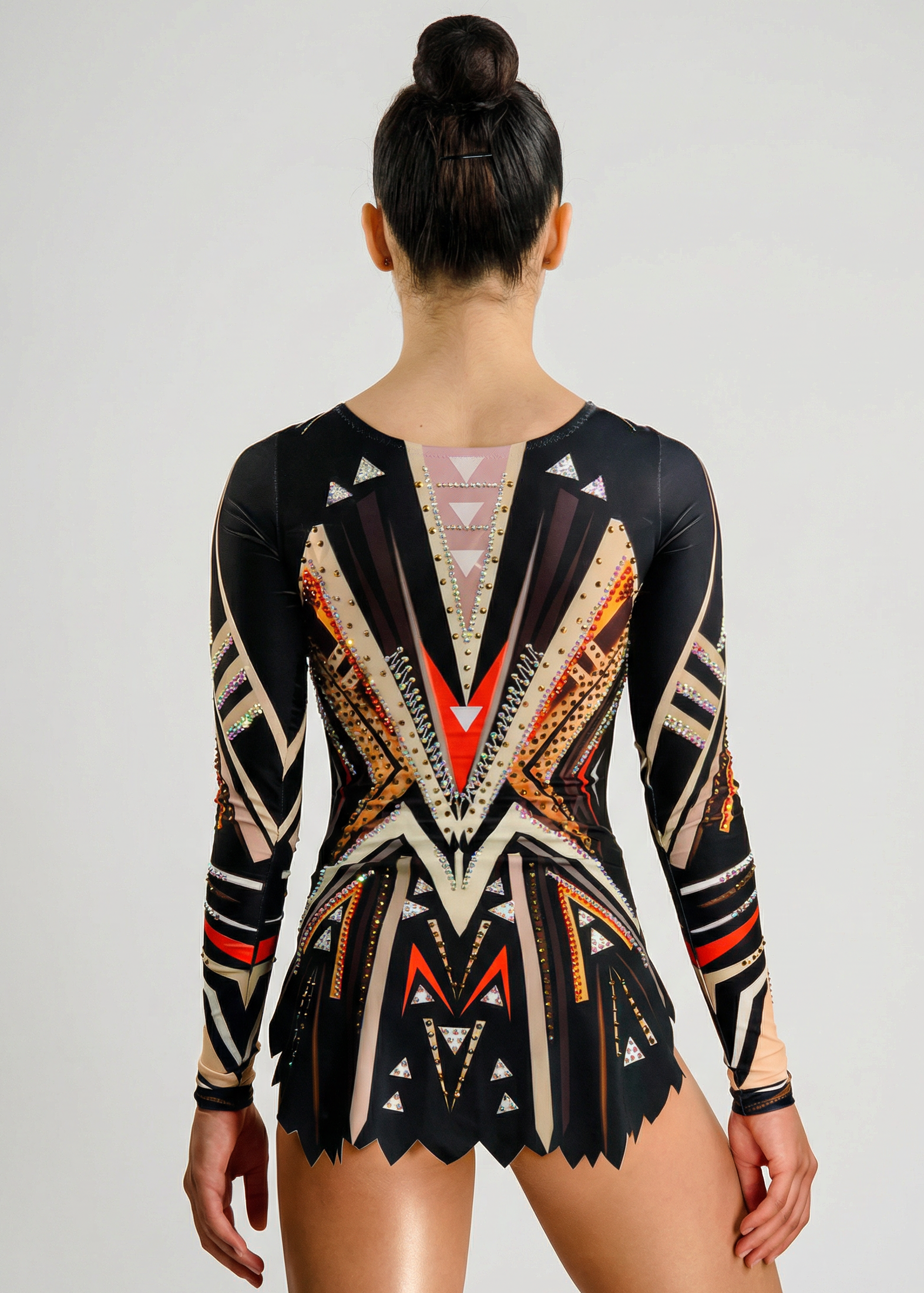 Maillot de gimnasia rítmica en negro, beige y naranja con mangas largas, pedrería y patrones geométricos creando un estilo impactante.
Maillot de gimnasia rítmica en tonos negros y beige con detalles naranjas, pedrería y diseño geométrico de apariencia dinámica.
Maillot de gimnasia rítmica visto por la espalda en negros y beige con pedrería y motivos geométricos formando un estilo marcado.