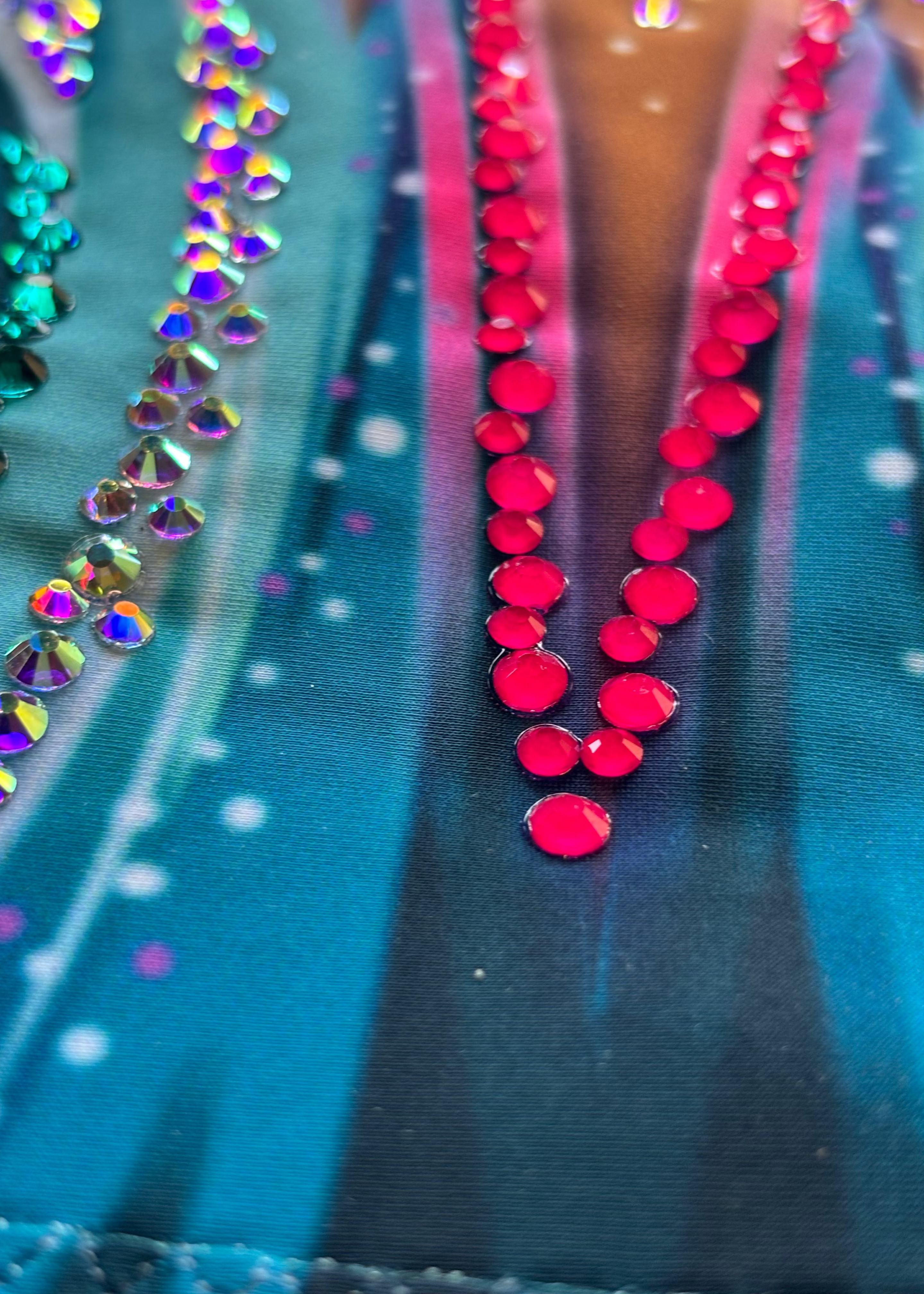 Body da ritmica blu ciano con sfumatura fucsia e decorazione di strass brillanti sul petto.