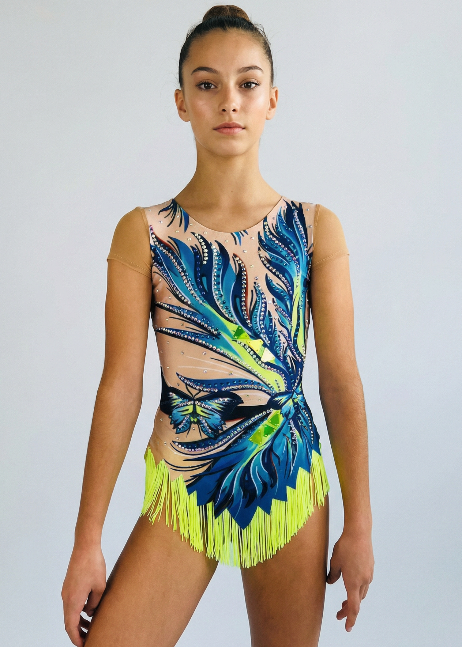 Maillot de gimnasia rítmica en tonos azules y verdes con degradados, pedrería, mariposas y flecos amarillos creando un estilo vibrante.

Maillot de gimnasia rítmica color claro con azules intensos, detalles verdes, pedrería brillante, transparencias simuladas y flecos amarillos de estilo dinámico.

Maillot de gimnasia rítmica visto por la espalda con base clara, pedrería sutil y motivos azules y verdes que forman un diseño fluido.