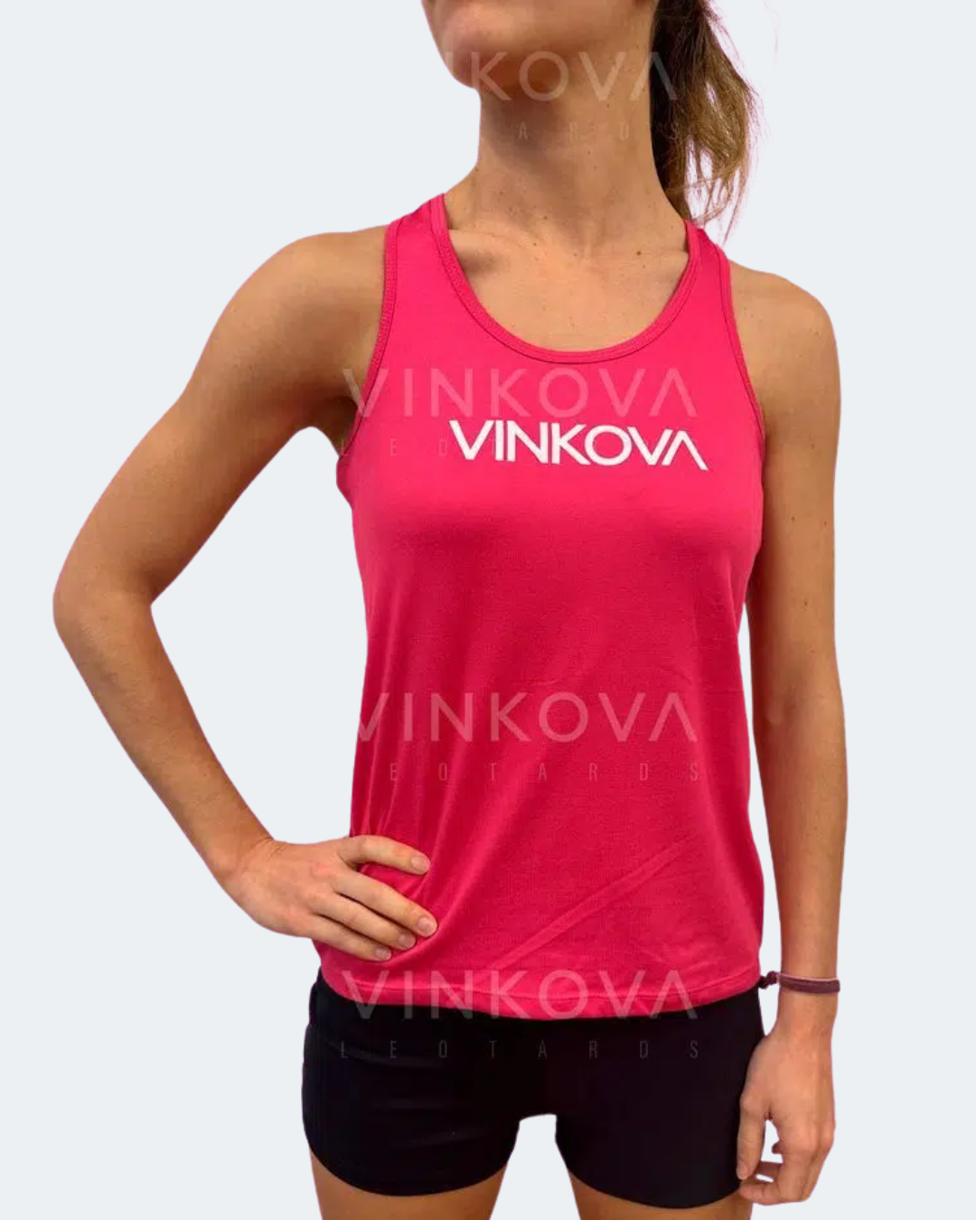 Canotta Vinkova, colore rosa, con logo bianco e shorts neri.