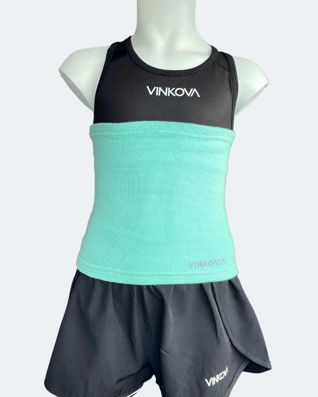 Fascia scaldavita Vinkova, colore turchese, su un manichino con completo nero.