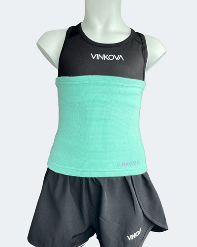 Fascia scaldavita Vinkova, colore turchese, su un manichino con completo nero.