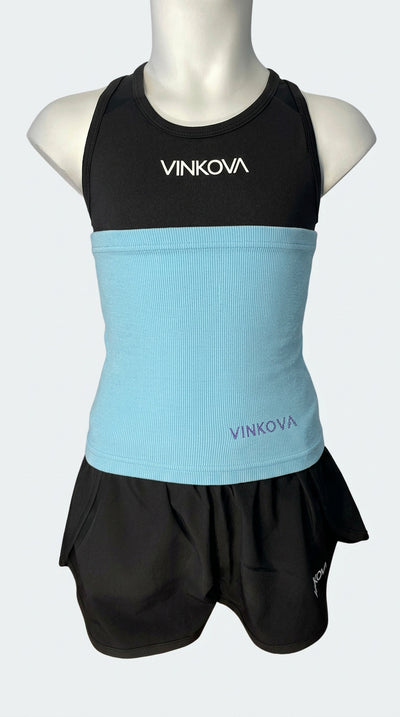 Fascia scaldavita Vinkova, colore celeste, su un manichino con completo nero.
