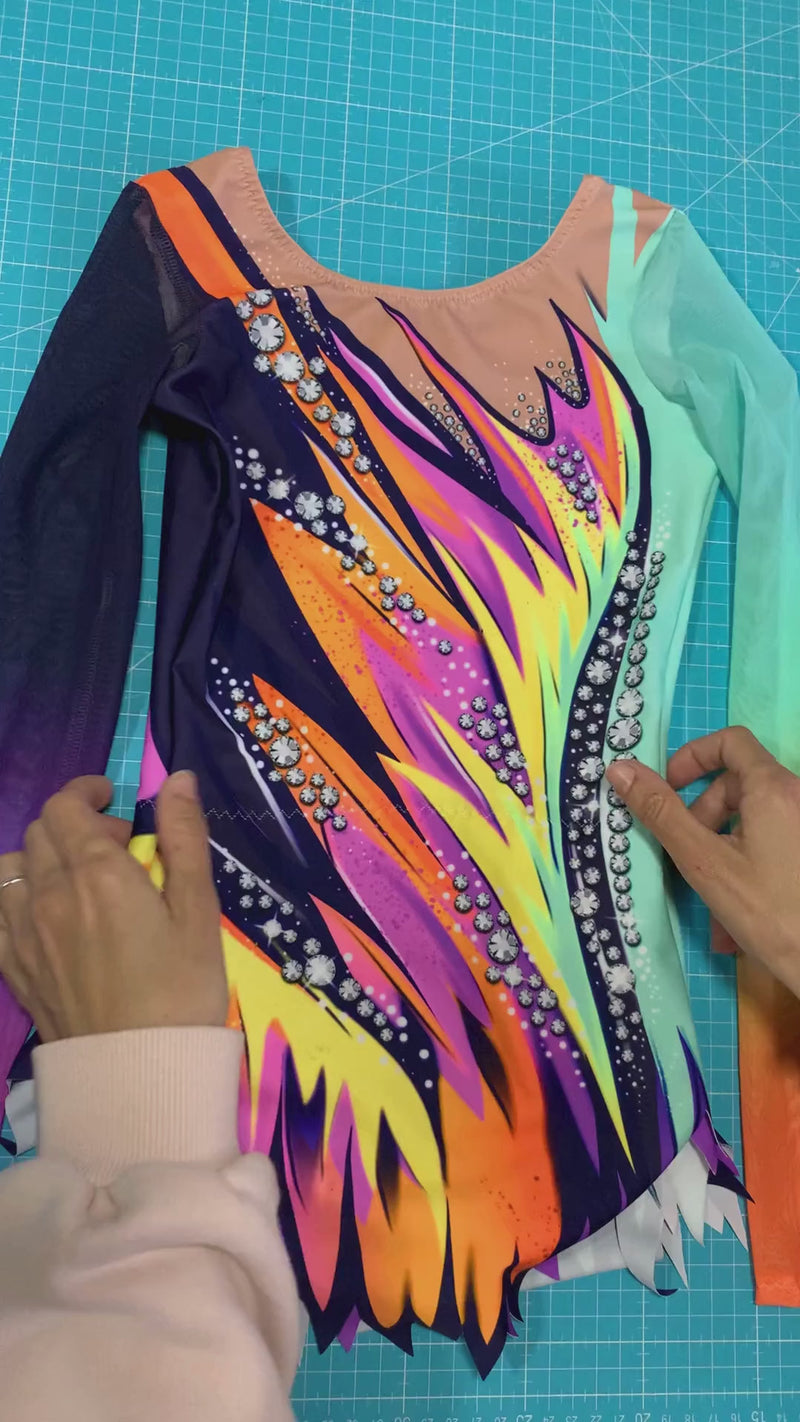 Maillot rítmico profesional con motivos de llamas en tonos cálidos y fríos para una máxima visibilidad en tapiz.