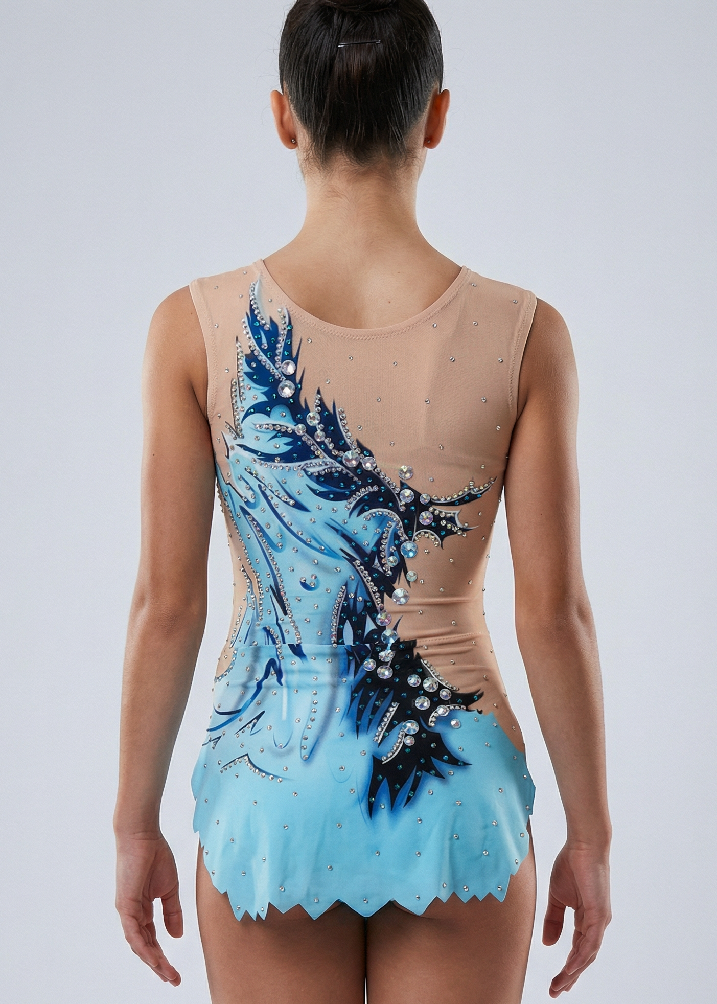 Maillot de gimnasia rítmica en azul y celeste con pedrería abundante, degradados suaves y motivos fluidos creando un estilo acuático.

Maillot de gimnasia rítmica color claro con azules intensos, detalles celestes, pedrería brillante y diseño ondulado de apariencia dinámica.

Maillot de gimnasia rítmica visto por la espalda en base clara con azules y celestes, pedrería y motivos fluidos de estilo acuático.